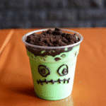 Frankenstein Pudding Cups with Oreo hair and candy eyes on a Halloween table