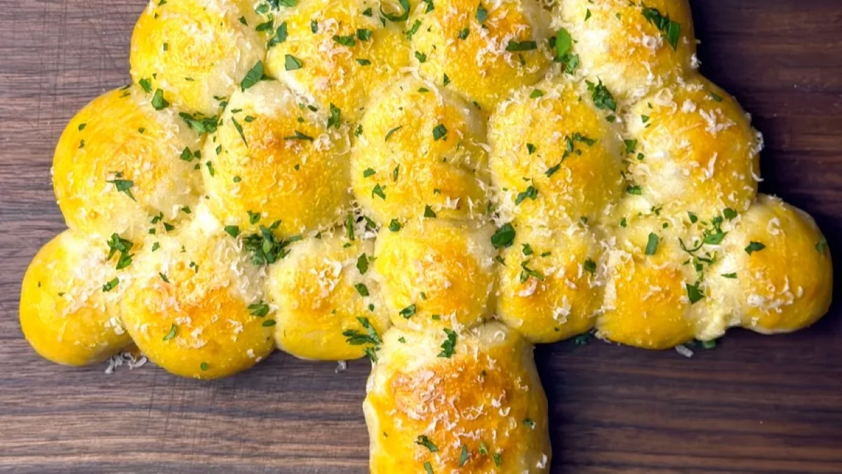 Cheesy Pull-Apart Bread Christmas Tree: Your New Holiday Showstopper! Cheesy Pull-Apart Bread Christmas Tree Cheesy Pull-Apart Bread Christmas Tree with melted mozzarella and parsley on a wooden board