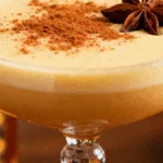 Close-up of a garnished Fireball Eggnog cocktail in a coupe glass
