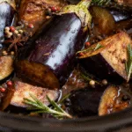 Delicious slow-cooked aubergine recipe in a rustic slow cooker.