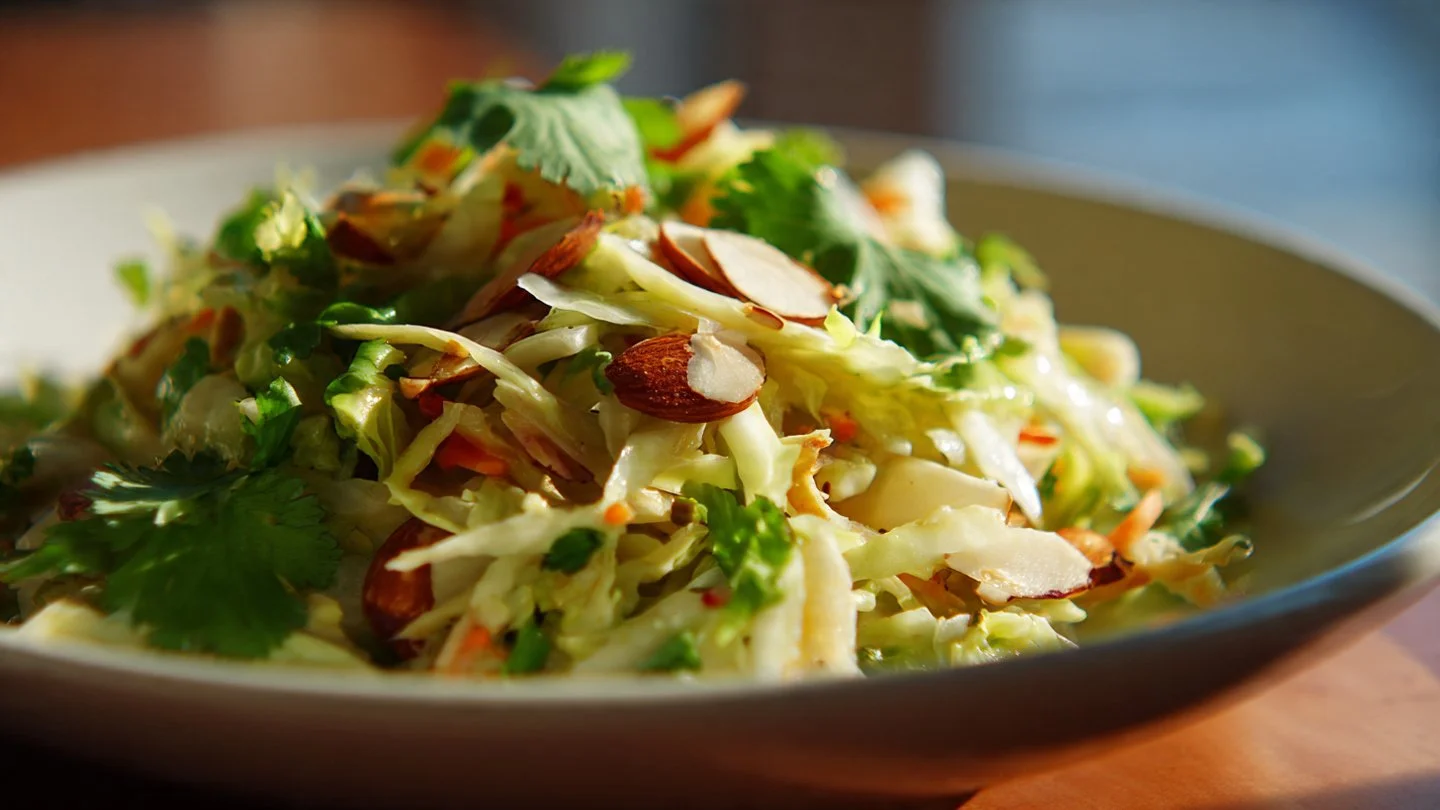 Fennel slaw with apple, cabbage, and green mayonnaise served in a bowl.