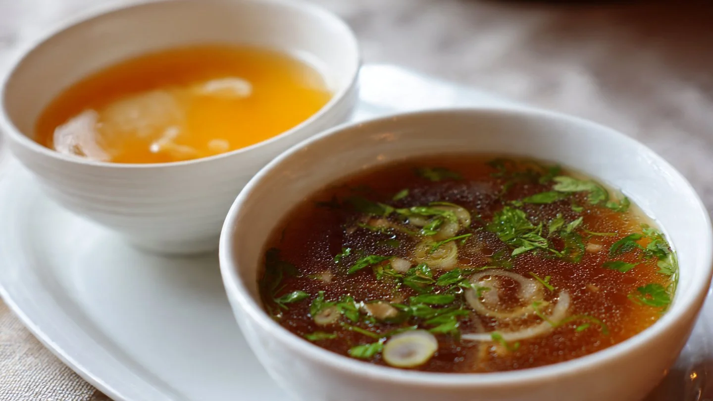 Delicious Japanese clear onion soup served in a bowl with garnishes.