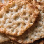 Homemade Lemon Rosemary Flatbread Crackers on a wooden serving board